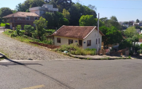 Terreno de esquina no Cerâmica, com casa de madeira